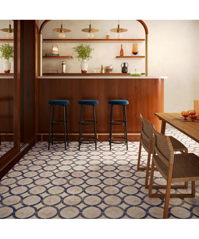 Modern bar interior with wooden counter, stools, and patterned floor.