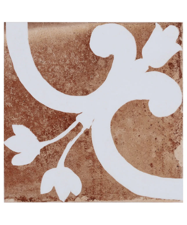 Decorative tile with white floral design on a brown background