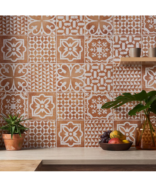 Patterned tiles on a wall with decorative elements and plants.