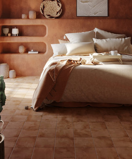 Bedroom with terracotta walls, bed, and shelves with decorative items.