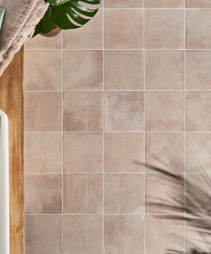 Bathroom setting with tiled wall, towel, and plant