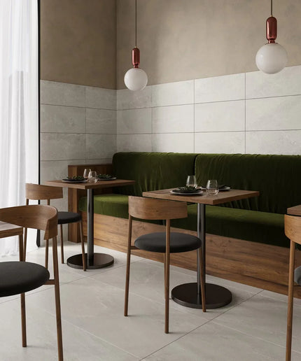Modern restaurant interior with wooden tables, chairs, and a green booth.