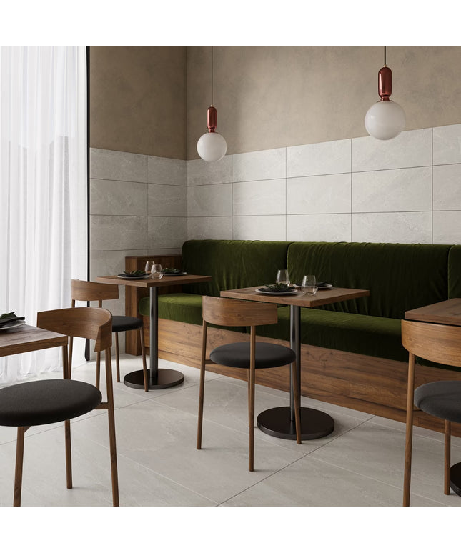 Modern restaurant interior with wooden tables, chairs, and a green booth.