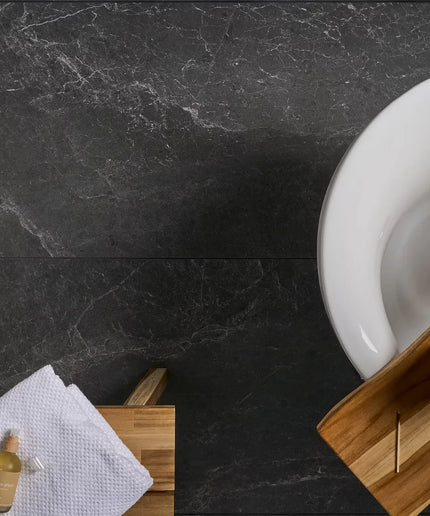 Bathroom setting with a white sink on a dark marble countertop