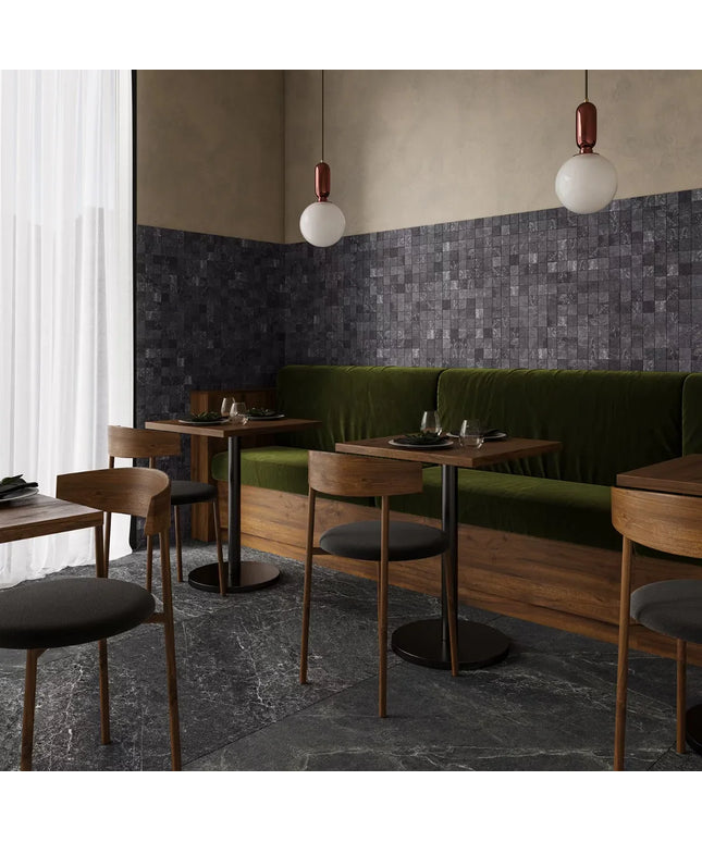 Modern dining area with dark graphite mosaic tile accent wall and marble-look floor tiles