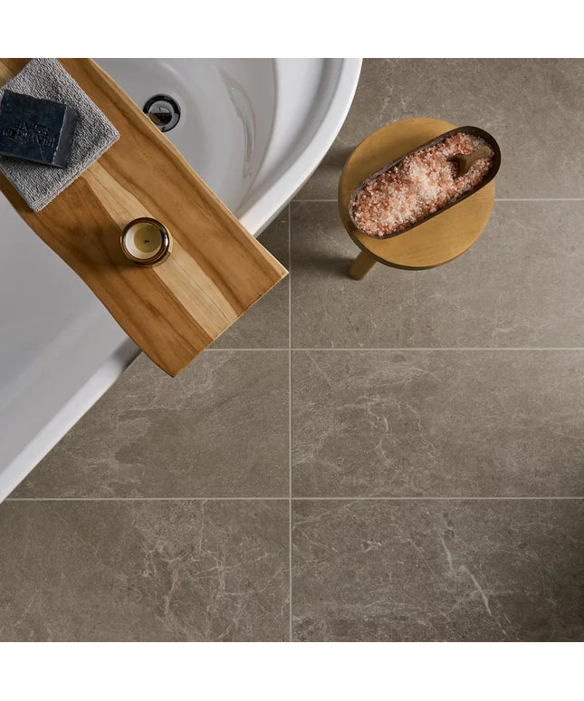 Bathroom setting with a wooden shelf, bath, and salt lamp on a tiled floor.