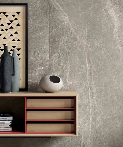 Modern interior design with a sideboard, decorative items, and a framed artwork against a gray marble wall.
