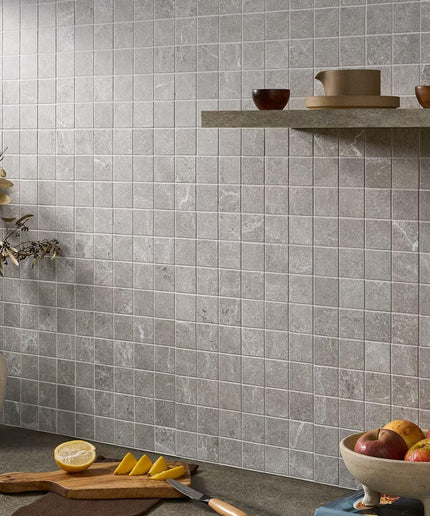 Gray tiled wall with a shelf and kitchen items