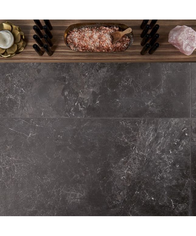Dark stone surface with decorative items including a bowl of pink salt, a wooden spoon, and a crystal.