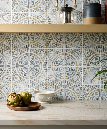 Decorative tile pattern on a kitchen wall with a shelf and plants.