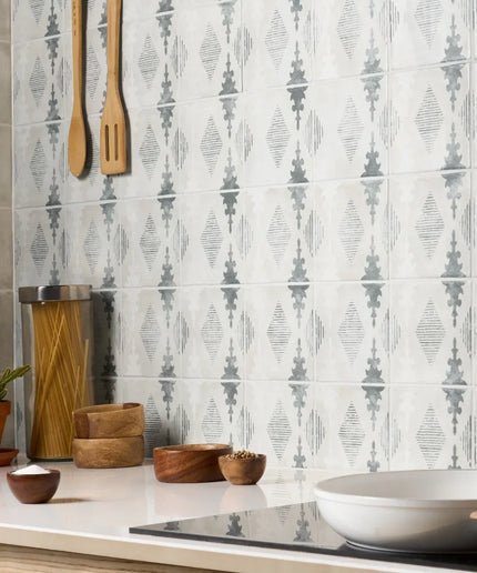 Kitchen with patterned tiles on the wall, wooden utensils, and decorative elements.