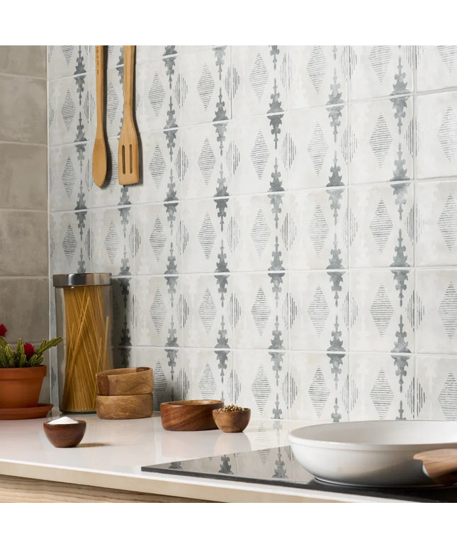 Kitchen with patterned tiles on the wall, wooden utensils, and decorative elements.
