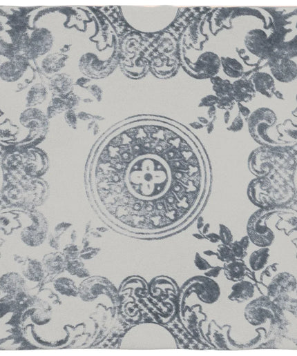 Decorative tile with blue floral and leaf pattern on a white background
