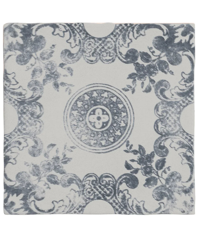 Decorative tile with blue floral and leaf pattern on a white background