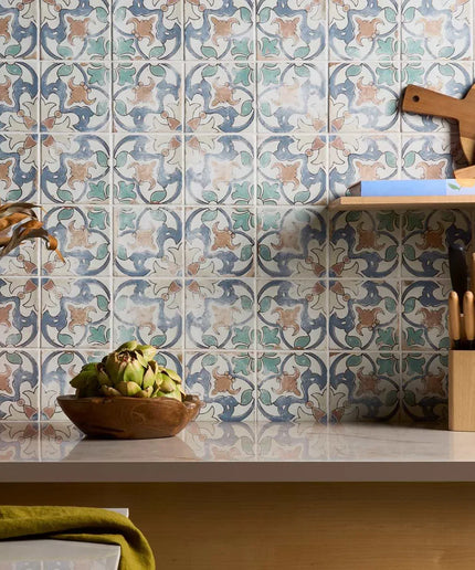 Decorative tile pattern on a kitchen wall with a wooden cutting board and knife block.