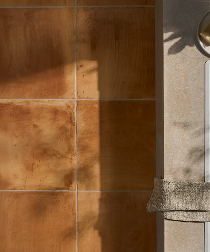 Peach terracotta-style floor tiles next to a beige countertop and sink in natural light