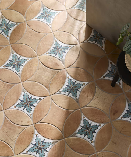 Patterned tile floor with decorative elements and a plant in the corner.