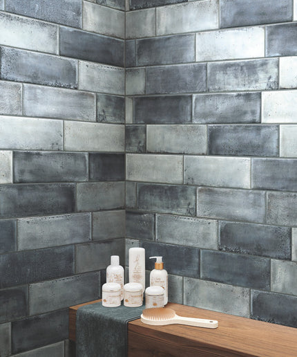 Bathroom corner with tiled wall and toiletries on a wooden surface