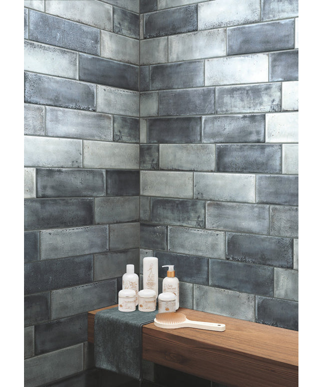 Bathroom corner with tiled wall and toiletries on a wooden surface