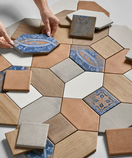 Hexagonal tiles with decorative patterns being arranged on a surface