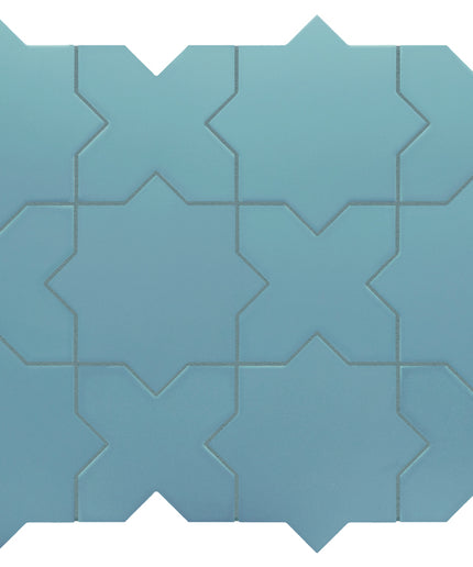 A set of interlocking geometric mosaic tiles in a dusty blue color, arranged in a grid pattern against a plain white background.