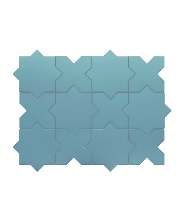 A set of interlocking geometric mosaic tiles in a dusty blue color, arranged in a grid pattern against a plain white background.