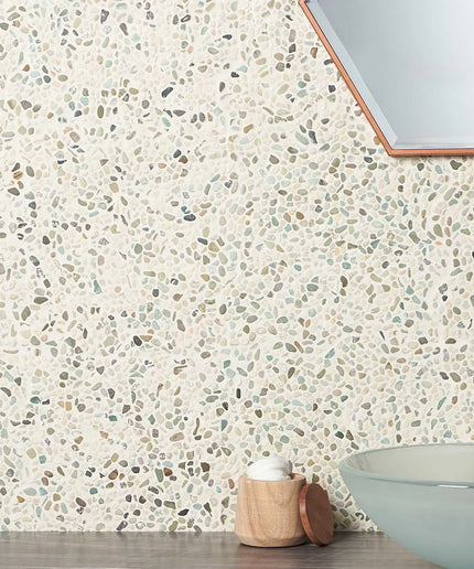 Terrazzo stone wall tiles in bathroom with glass sink and hexagonal mirror