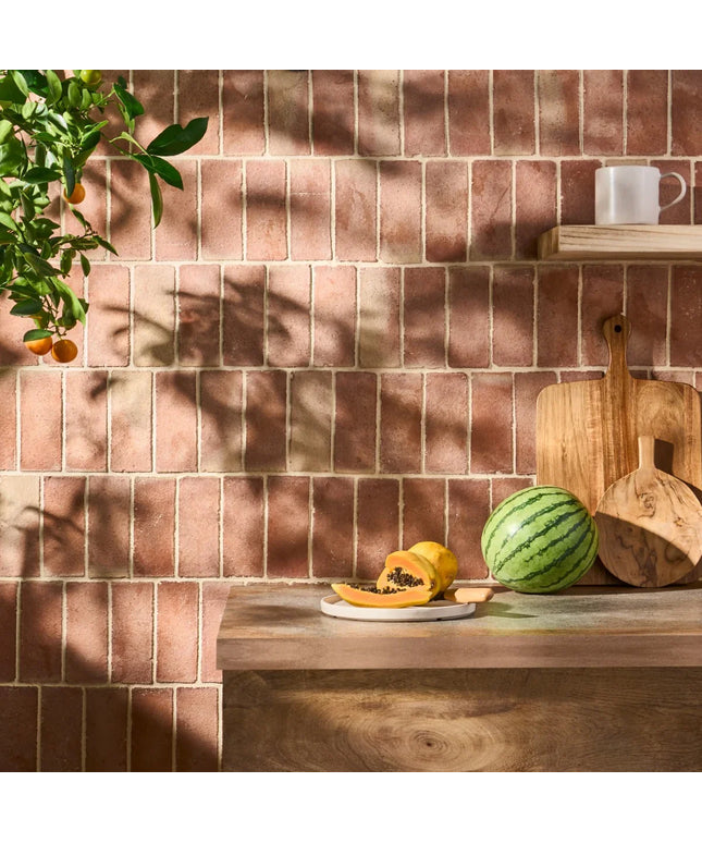 Kitchen counter with fruits against a tiled wall