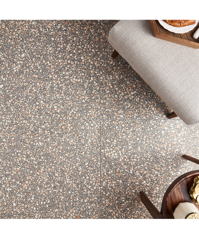 Terrazzo-style floor with speckled pattern and gray upholstered chair.