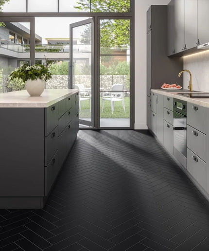 Modern kitchen with black herringbone subway tile floor and grey cabinets