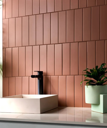 Modern bathroom with 3x11 matte terracotta subway tiles, vessel sink, and green plant