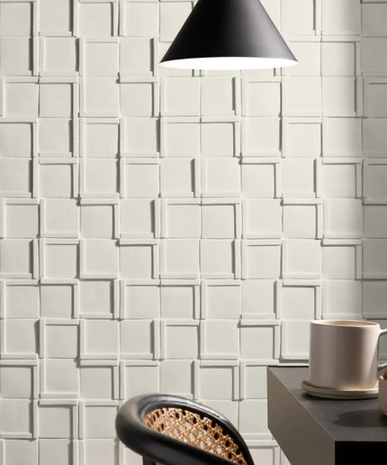 White textured wall tiles with a coffee cup and saucer on a table.