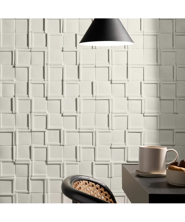 White textured wall tiles with a coffee cup and saucer on a table.