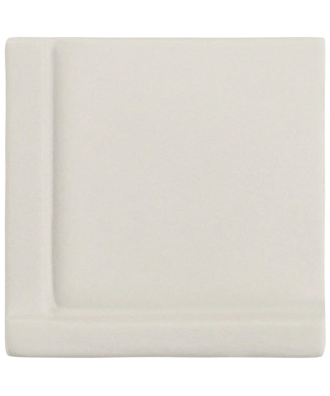 White fitted sheet on a bed with a plain background