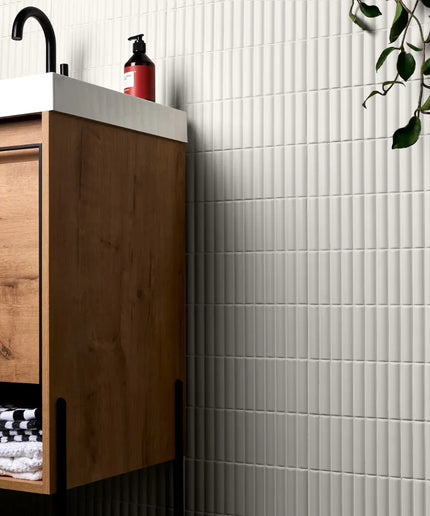 Bathroom with wooden vanity, white tiles, and a plant