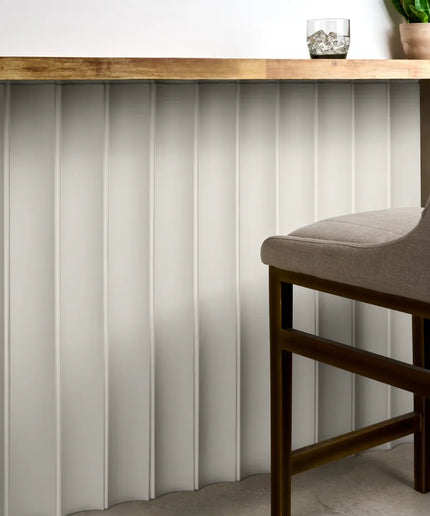White fluted column tiles used as bar front wall paneling with wood countertop and chair