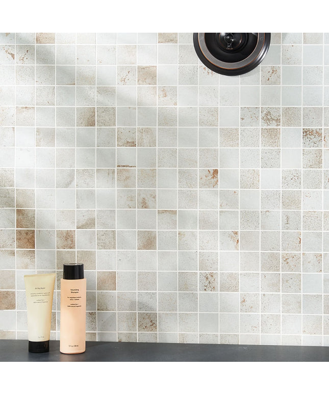 Two skincare products on a bathroom counter with a tiled wall background