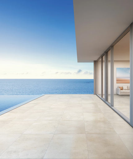 Modern house with a large glass door overlooking a blue ocean.