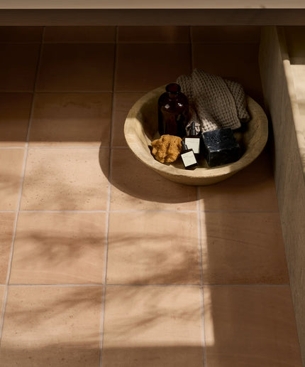 Sand terracotta 9x9 floor tiles in natural light with a bowl of spa accessories