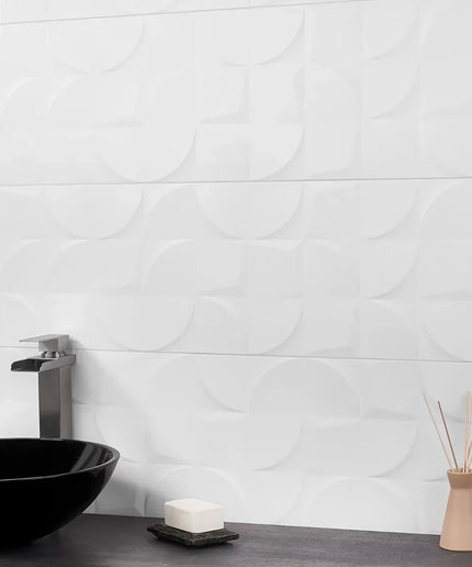Bathroom setting with a black sink, soap, and diffuser against a white tiled wall.