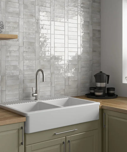 Glossy grey 2x6 wall tiles backsplash in modern kitchen with farmhouse sink