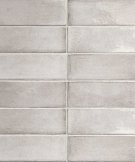Glossy light grey rectangular subway tiles in a staggered brick pattern