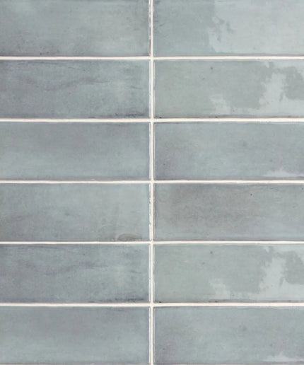 Glossy light blue rectangular wall tiles with subtle color variation and white grout