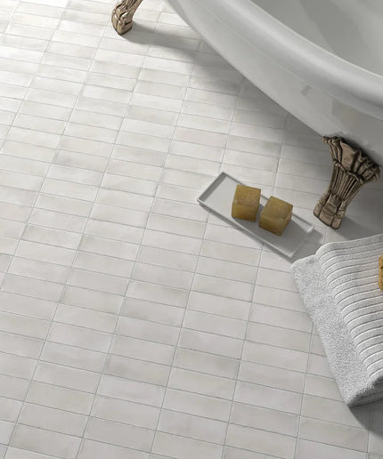 White gloss 2x6 wall tiles in a bathroom with clawfoot tub, sponge, and folded towels