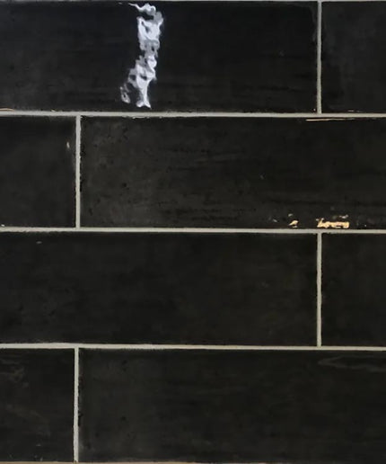 Glossy charcoal black subway tiles with light grout, ideal for kitchen backsplash or bathroom walls