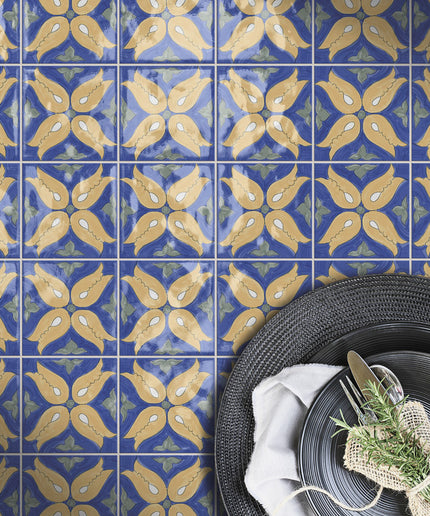 Blue and yellow decorative ceramic tiles with floral pattern, tableware on side