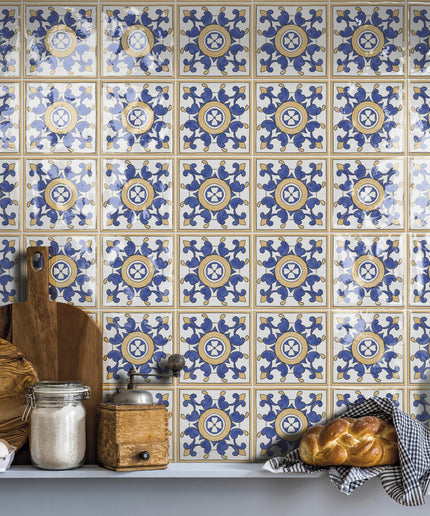 Blue and white patterned kitchen backsplash tiles with wood and bread on countertop