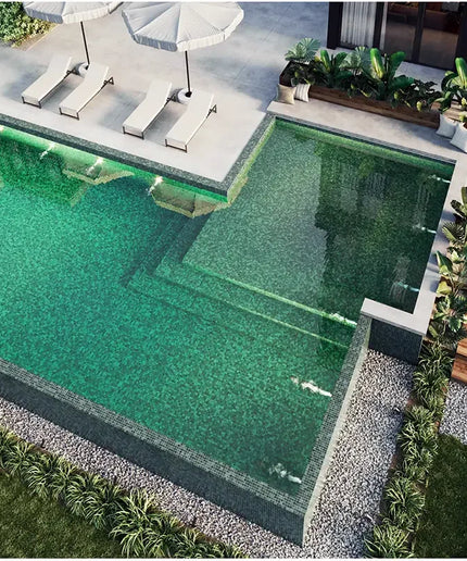 Sukabumi pool tiles. Rectangular pool with green water, surrounded by lounge chairs and plants in a backyard setting.