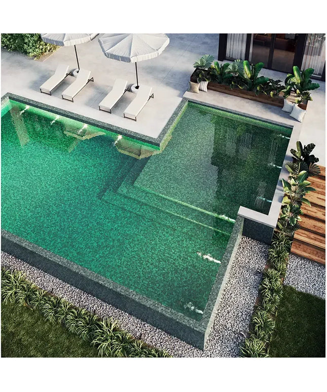 Sukabumi pool tiles. Rectangular pool with green water, surrounded by lounge chairs and plants in a backyard setting.