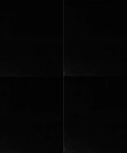 Black square tile with a subtle pattern on a black background